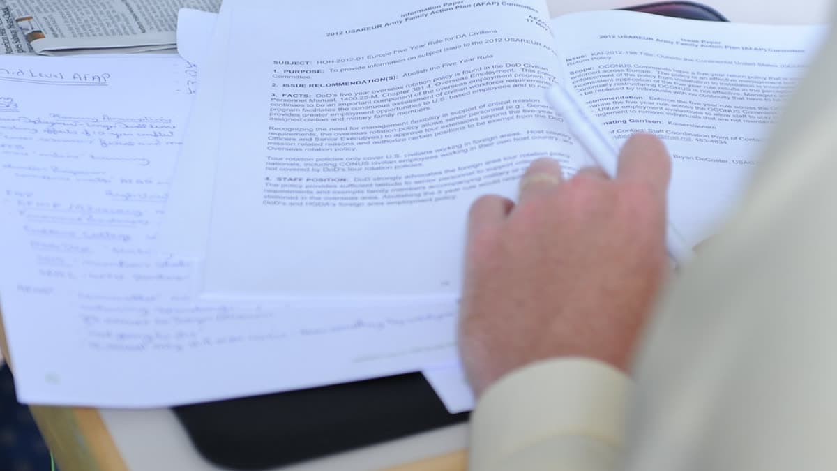 Hands reviewing printed documents at an office desk